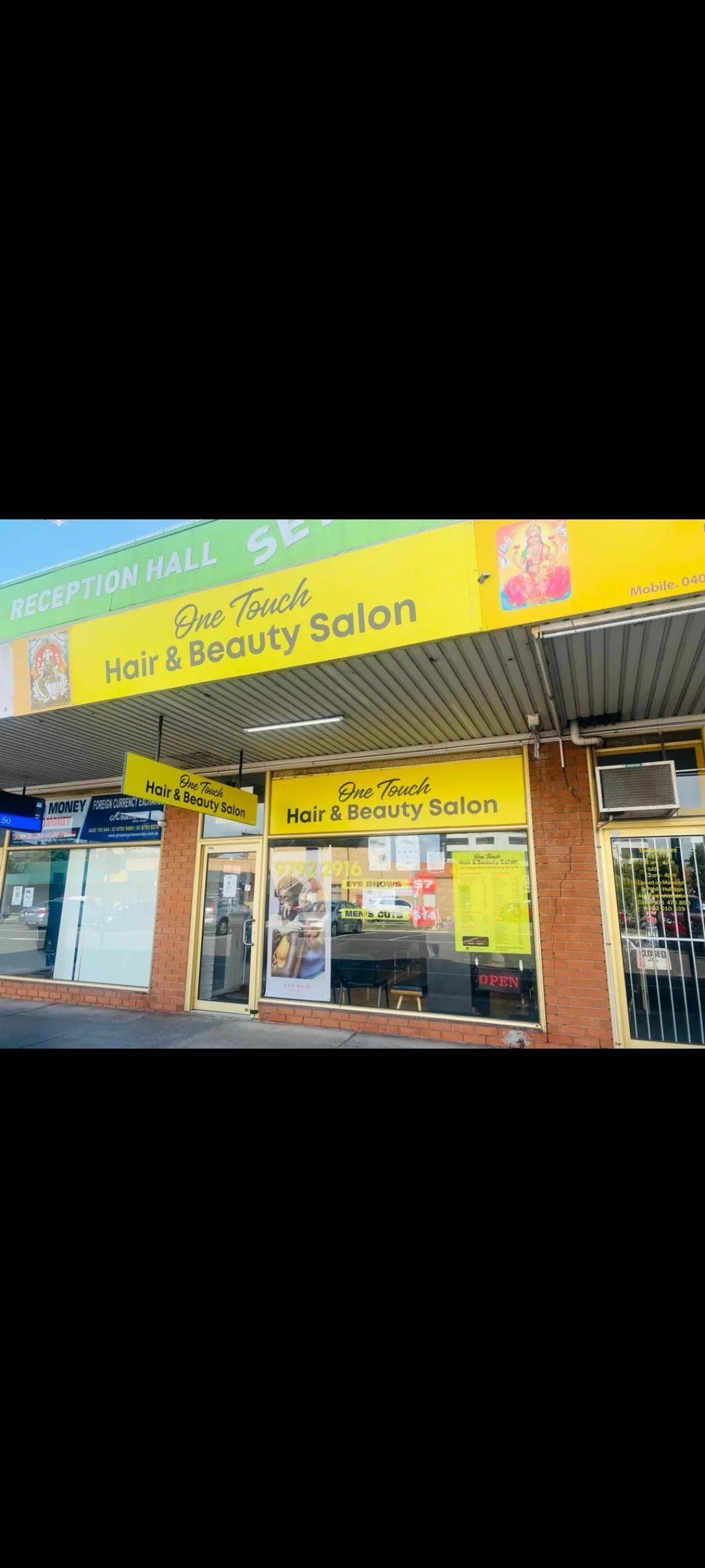 Exterior shopfront: tall crop of the yellow One Touch Hair and Beauty Salon facia