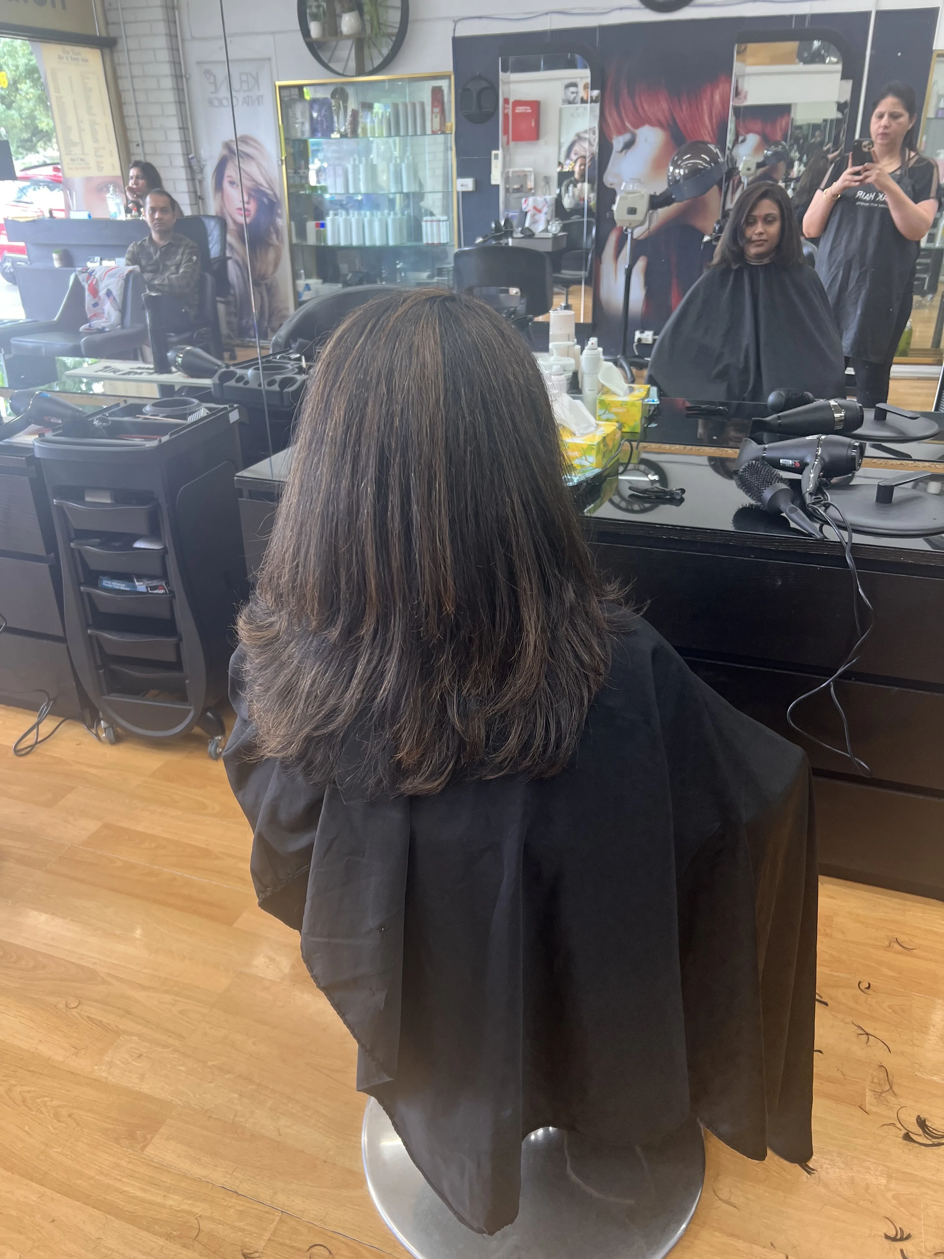 Rear view of sleek straight dark hair at a station, clean background