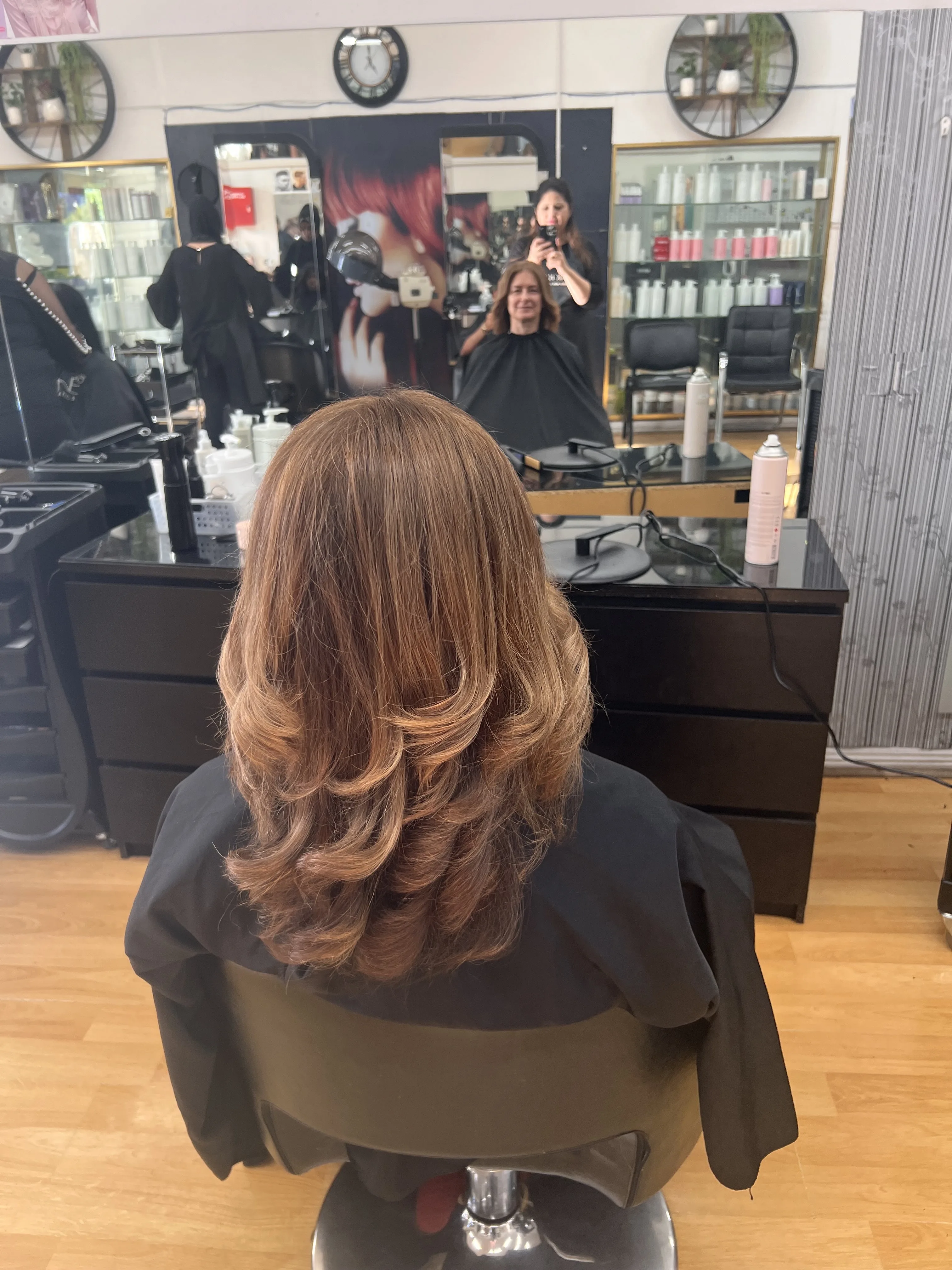 Rear view of layered caramel blow-wave with curled ends