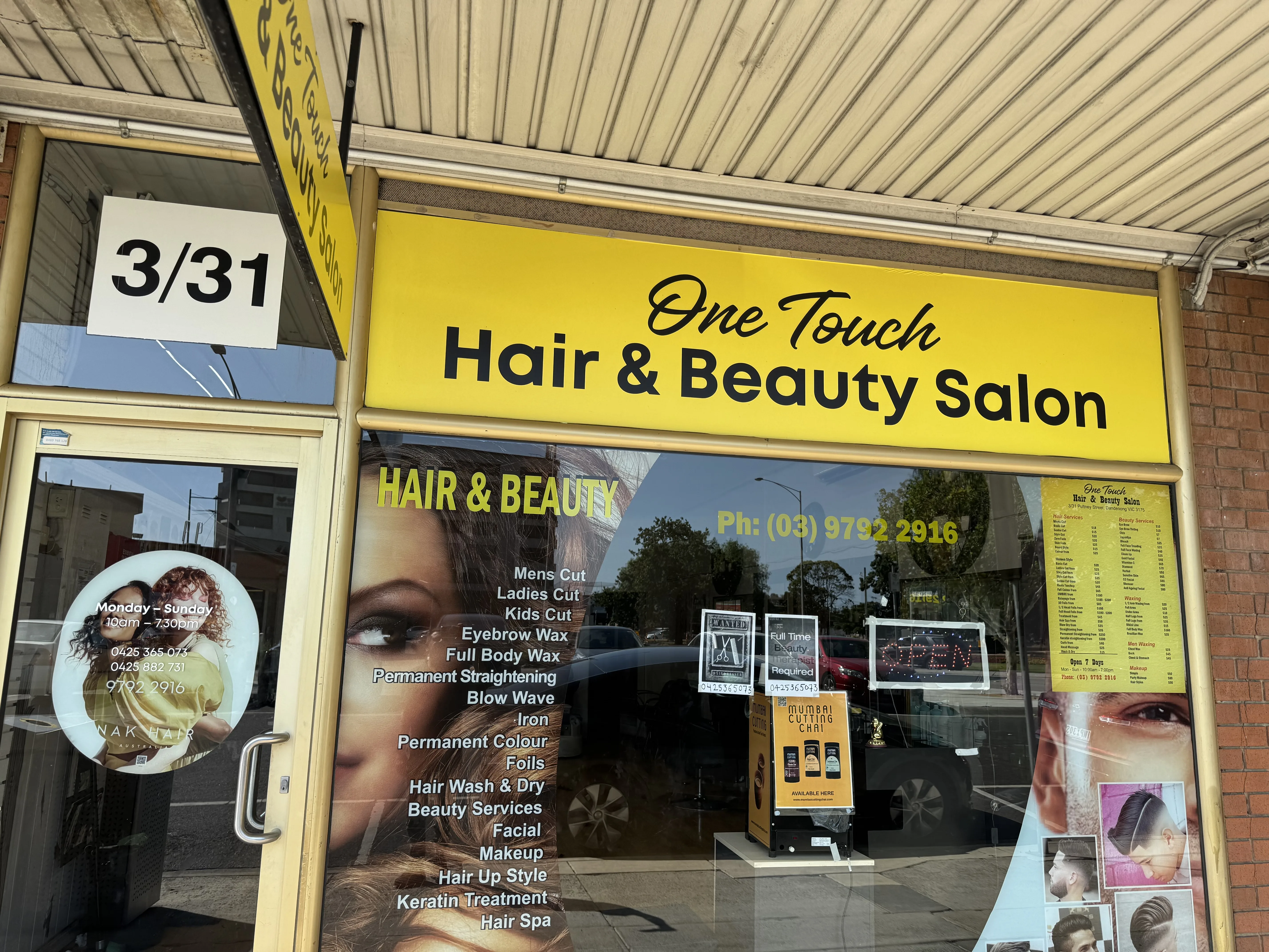 Wide angled exterior view of the bright yellow One Touch Hair and Beauty Salon shopfront
