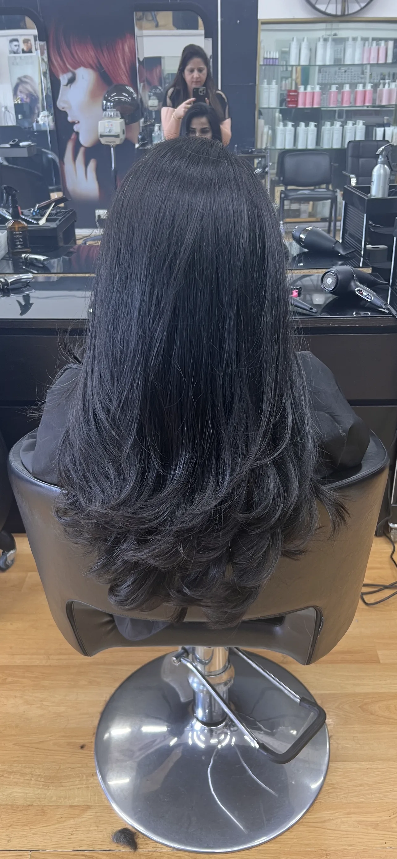 Rear view of dark wavy hair, mirror reflections behind