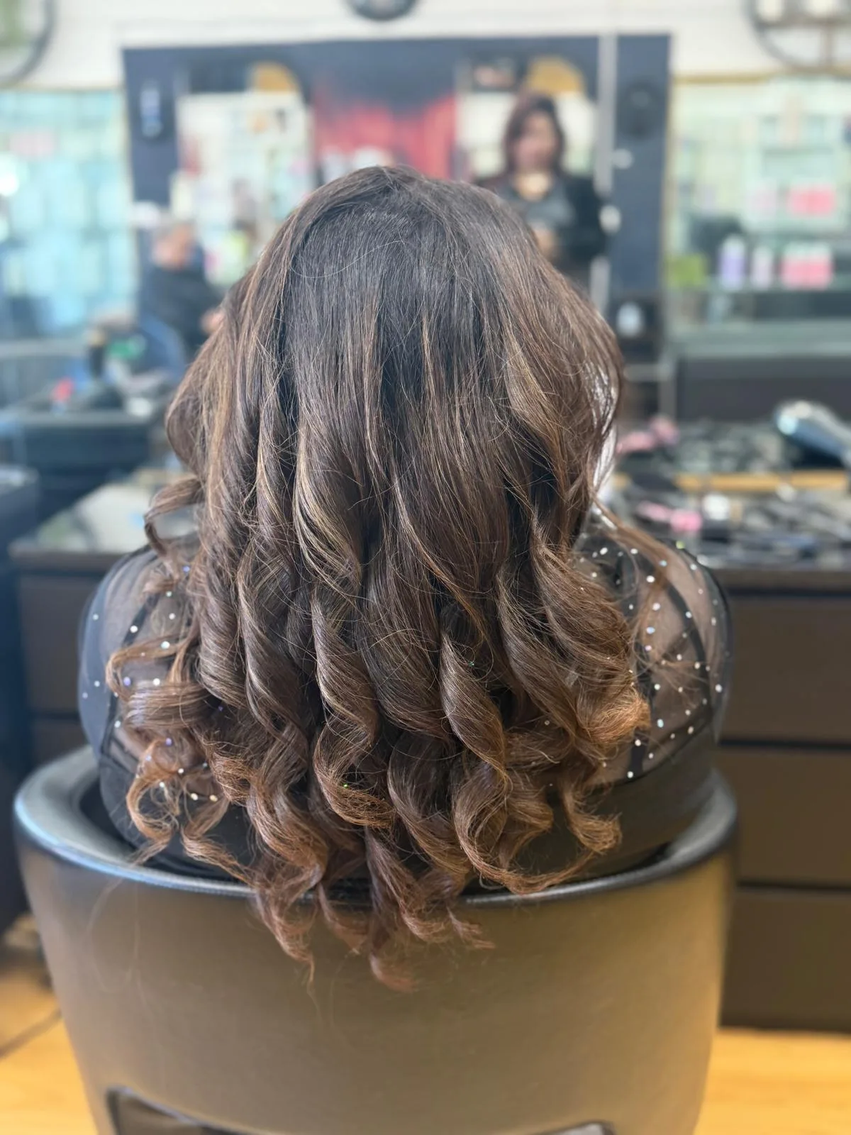 Rear view of voluminous warm-brown bridal curls set with pearl pins